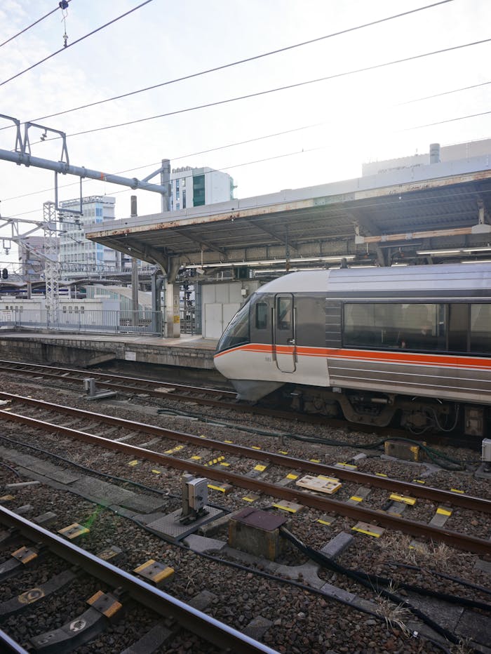 A sleek train at a modern urban station showcasing tracks and transportation infrastructure.