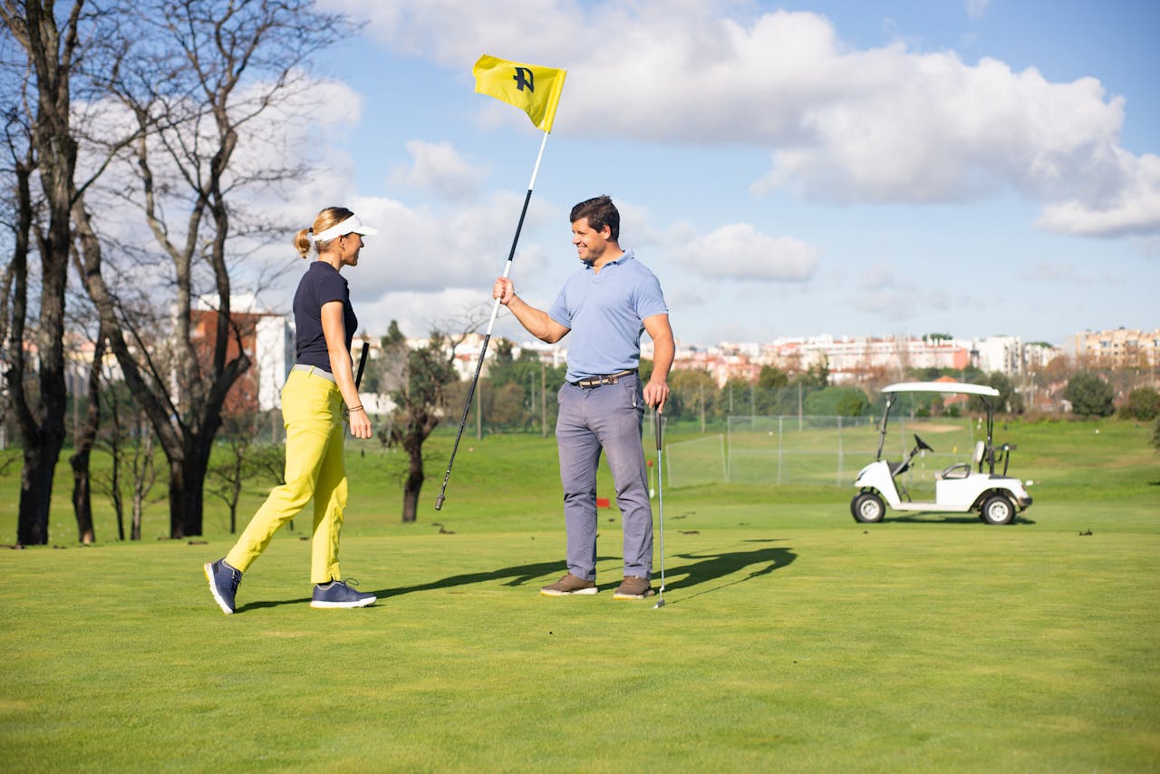 Two golfers sharing a moment on a bright day in a lush golf course setting in Portugal.